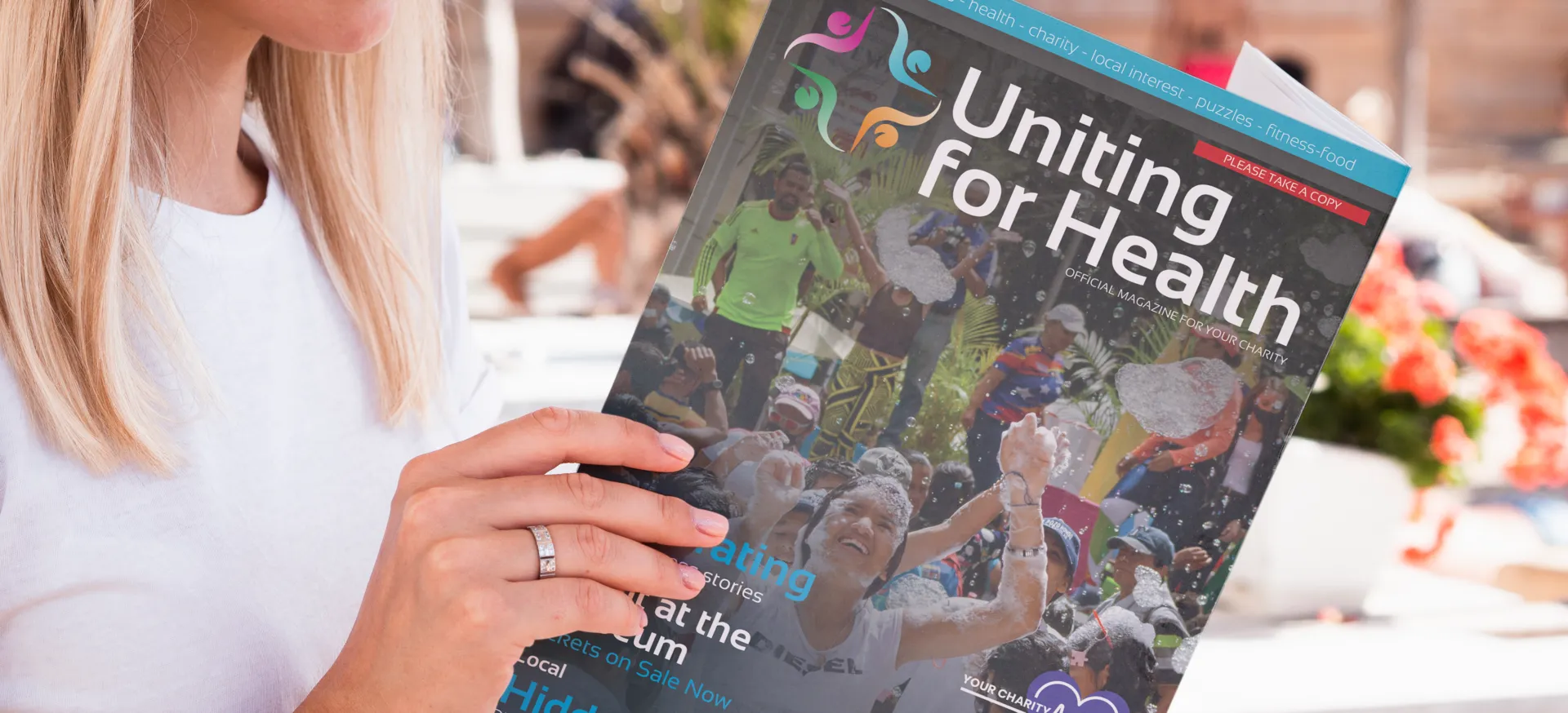 A reader holding the Uniting For Health magazine