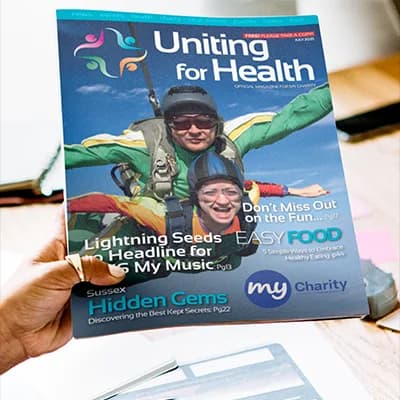 A reader holding up the Uniting For Health magazine